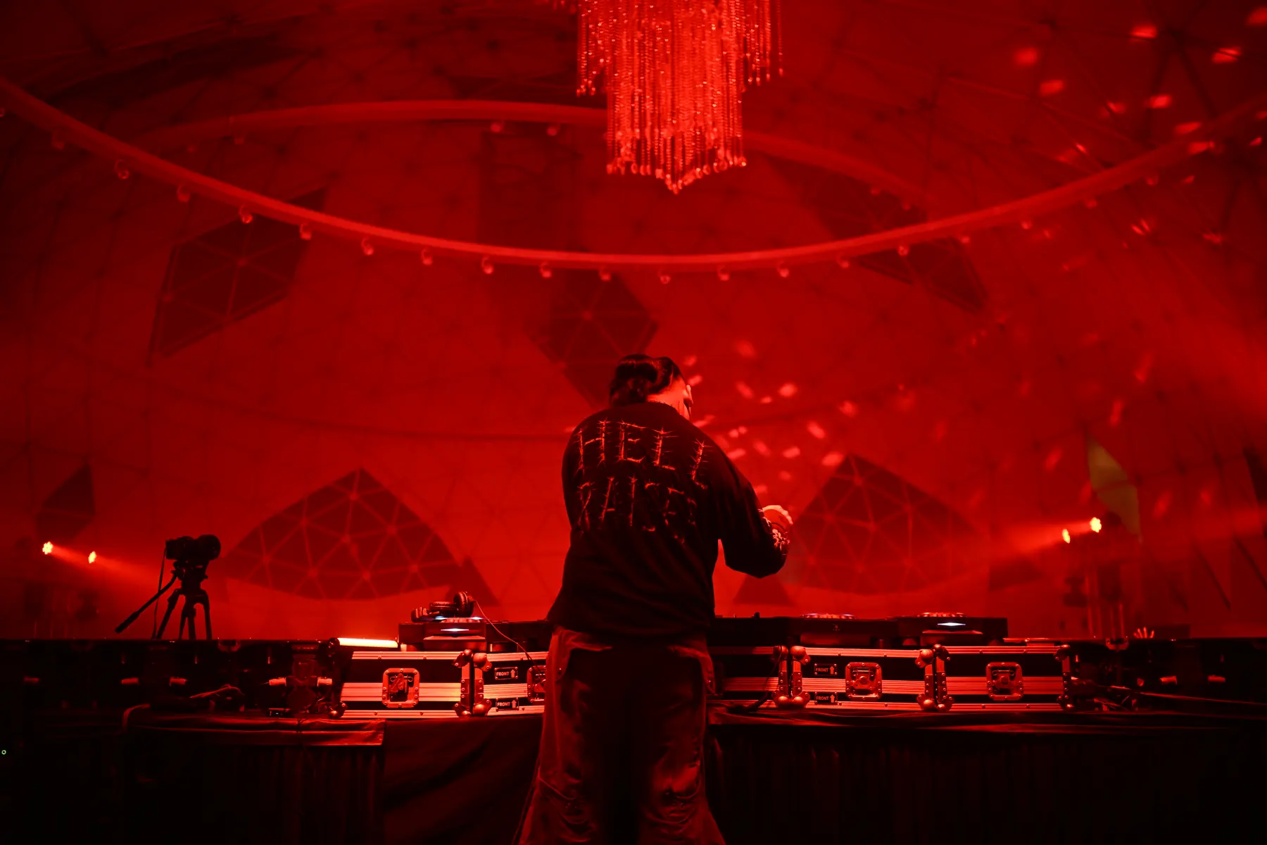 DJ playing under a red-lit geodesic dome at the Kamikaze event